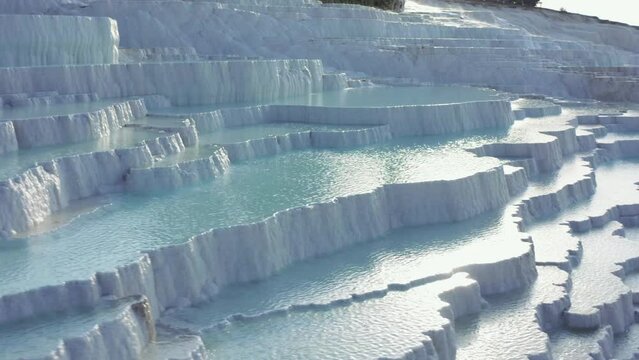 White travertine terraces or travertine pools that cascade down the hillside in Pamukkale.  Amazing close up macro drone footage of iconic landmark Pamukkale, Cotton Castle. 4K