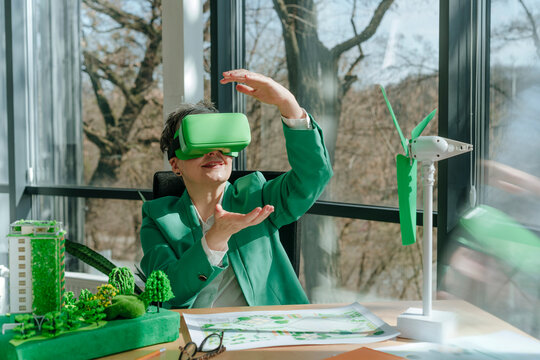 Businesswoman wearing VR glasses gesturing in green office