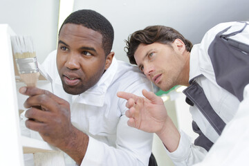Obraz premium apprentice painter receiving instructions from mentor