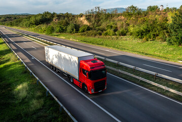 Big Red Transportation Truck on a highway road through the countryside