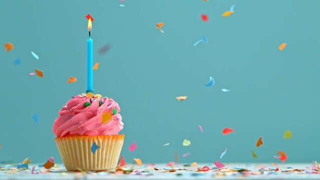 Birthday Cup Cake With Burning Colorful Candle on Pastel Blue Background. Super Slow Motion, 1000 FPS.