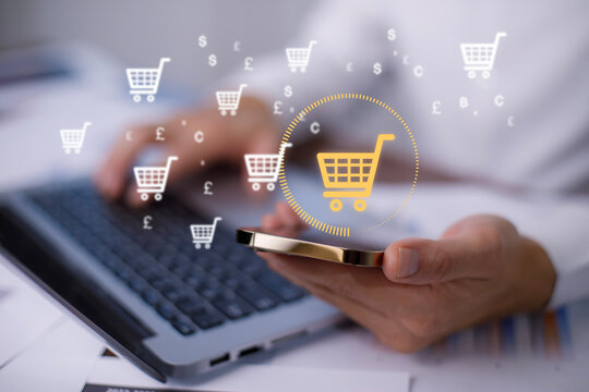 Businessman hold smartphone with online shopping concept, marketplace website with virtual interface of online Shopping cart part of the network, Online shopping business with selecting shopping cart.