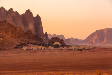 Camp site tents at Wadi Rum Desert, Jordan and red rocks sunset landscape