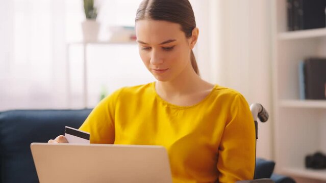 Young woman with disability having credit card problems while shopping on laptop