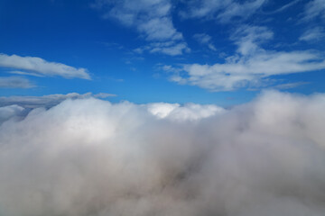 Atmosphere of flying above clouds. Sky thunderclouds, horizon line from an airplane drone. Creative background for design. Dawn, sun over clouds - positive travel concept of meditative joy of future