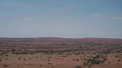 Driving plate side view moving through desert in car while filming. Long distance view of fields in arid areas. Road trip, driving auto traveling in wilderness.