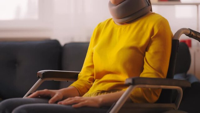 Sad woman wearing neck collar brace sitting in wheelchair, injury after accident
