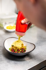 professional chef's hands cooking Raw beef meat tartar in restaurant kitchen