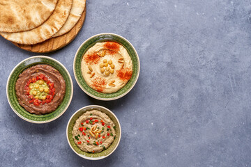 Middle eastern, arabic traditional breakfast with hummus, foul and baba ganoush. Top view with copy space