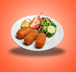 Floating White plate with three Shrimps croquettes ans salad