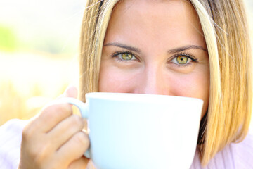 Happy teen with beauty eyes holding coffee mug