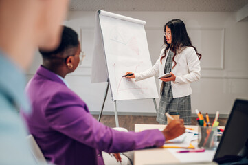 Fototapeta premium Asian businesswoman holding a presentation during a meeting in an office