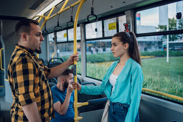 Couple talking while riding a bus in the city