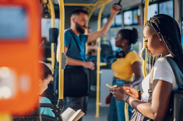 African american woman riding in a bus and using a smartphone