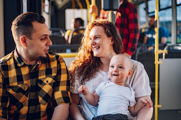 Happy parents and son riding in bus while baby sits in mother lap. © Zamrznuti tonovi