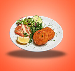 White plate with two Cheese croquettes ans salad
