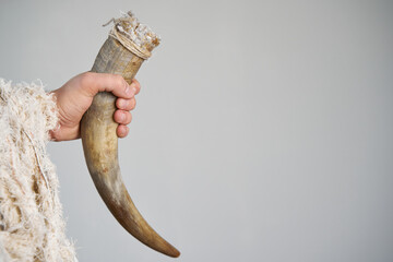 Barbarian and Viking arm with furr clothing holding bull horn as a drinking cup over neutral...