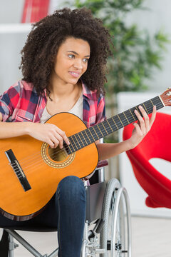 young lady in wheelchair playing guitar