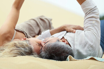 happy middle aged couple kissing on the beach