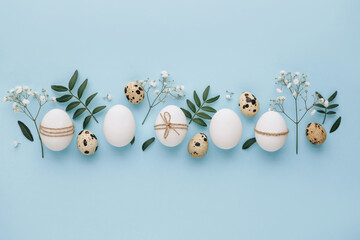 Composition with Easter eggs and flower blossom on blue background. Minimal easter concept.