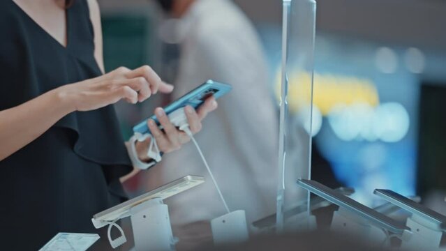 Close up of woman's hand choosing for buying a new smart phone in an electronics store