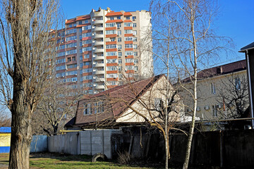 Fototapeta na wymiar Private houses against the backdrop of a high-rise residential complex