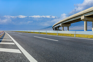 Asphalt road and bridge with snow mountain background