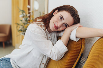 Obraz premium A young woman relaxes in her warm and inviting domestic room, filled with furniture and emotions.