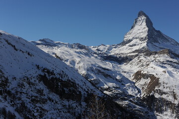 Fototapeta na wymiar Matterhorn peak in Zermatt in winter with snow and blue sky on a sunny day in the Alps, Switzerland
