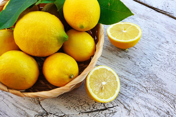 Obraz na płótnie Canvas lemons in basket on a wooden background