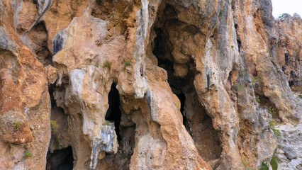 Close up of the rocky cliff of the mountain. Detailed view of eroded rock formation. Sandstone mountain rock texture.