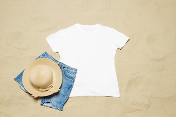 Sand beach texture background. Mockup white summer t-shirt outfit copy space. Blank template woman...