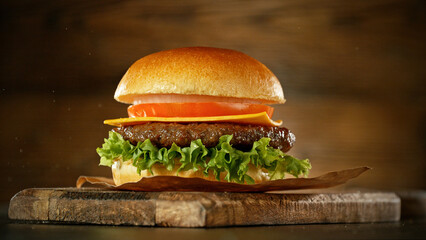 Delicious fresh cheeseburger with old wooden background. - obrazy, fototapety, plakaty