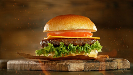 Delicious fresh cheeseburger with old wooden background.