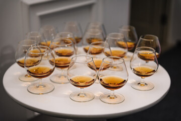 Whiskey, brandy in glasses on the table. Alcohol for the reception at the party for guests. Hard strong alcoholic drinks in glasses in the assortment: cognac, scotch, vermouth, rum.