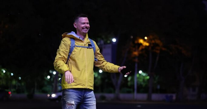 Hitchhiking, guy in the evening in the city on the road