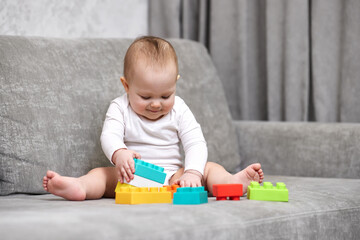 baby girl playing with colorful toy blocks