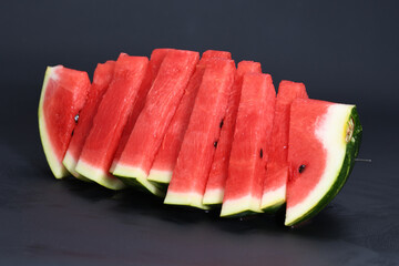 Cut pieces of red ripe delicious juicy watermelon on a black background