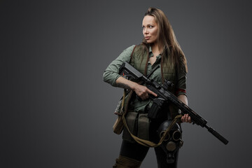 Fototapeta na wymiar Studio shot of professional killer woman with rifle in setting of post apocalypse.