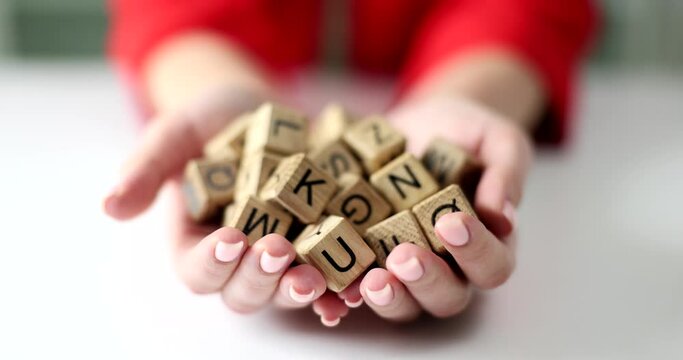 In the hands of a set of wooden blocks with letters, close-up