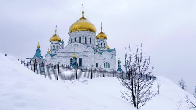 Belogorsky St. Nicholas Orthodox Missionary Monastery. Russia, Perm Krai, Belaya Gora. The temple on the hill in winter. Monastery on the background of snow. 4K