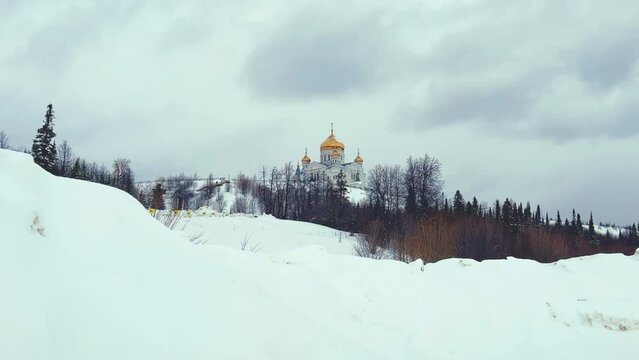 Belogorsky St. Nicholas Orthodox Missionary Monastery. Russia, Perm Krai, Belaya Gora. The temple on the hill in winter. Monastery on the background of snow. 4K