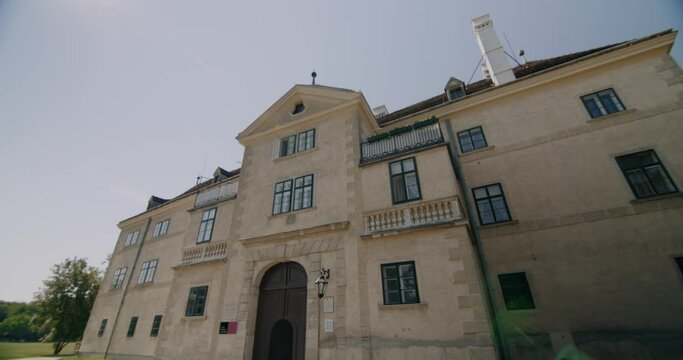 The film archive in Schlosspark Laxenburg in Austria (big old stone building), slowly tilting upwards keeping the building in the center) 