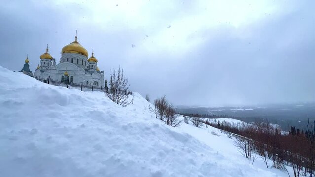 Belogorsky St. Nicholas Orthodox Missionary Monastery. Russia, Perm Krai, Belaya Gora. The temple on the hill in winter. Monastery on the background of snow. 4K