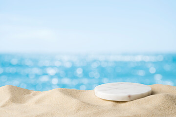 Marble podium in tropical sand over blurred tropical sea background