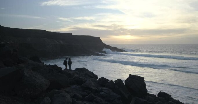 A couple is looking at the sunset in a beach in Fuerteventura