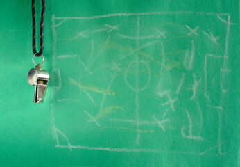 Plakat Whistle of soccer referee or trainer. Close up with soccer match tactics scribble on green background