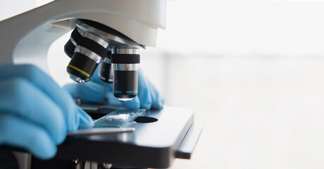 Medical laboratory, scientist hands using microscope for examining samples and liquid, Scientific...