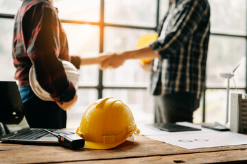 Construction team shake hands greeting start new project plan behind yellow helmet on desk in...