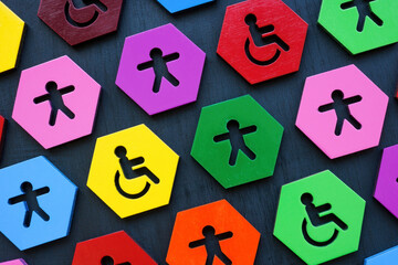 Inclusion and diversity. Colorful plates with figurines and disable person sign. - obrazy, fototapety, plakaty